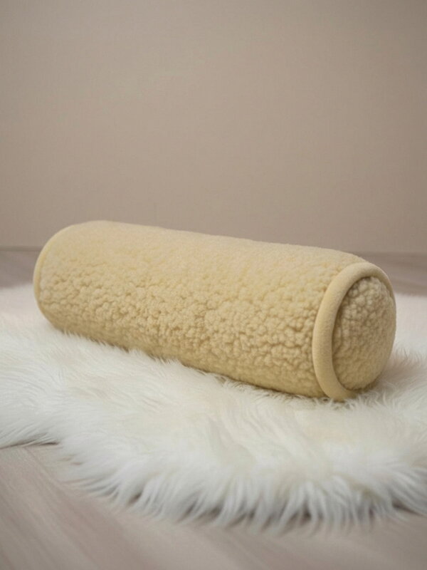 Kissen unter dem Kopf in Form eines Zylinders aus Schafwolle